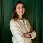 Flora Chabloz, fondatrice de la régie NORA, devant une porte verte à Nyon
