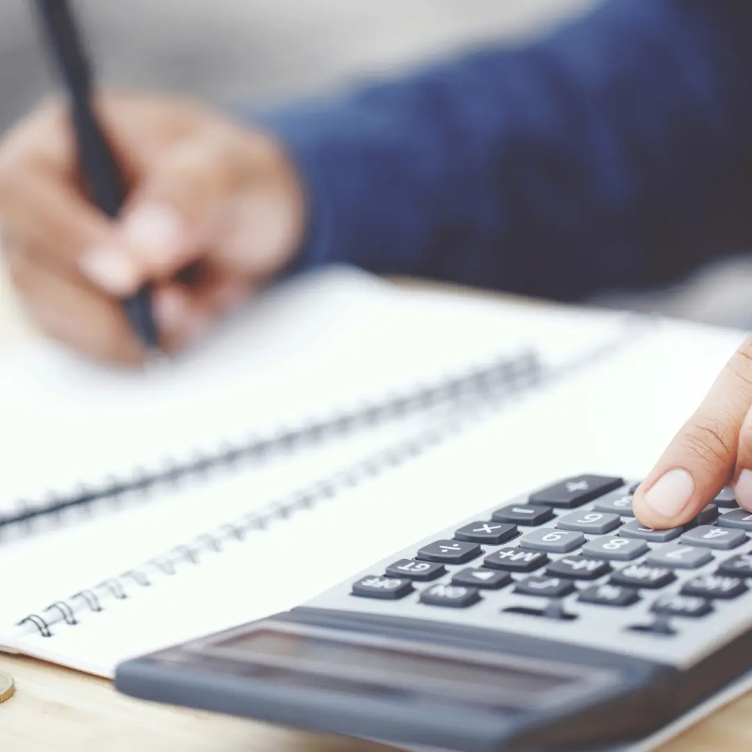 Calculatrice et cahier de comptes sur un bureau